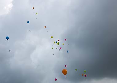 Baloons rising into the dark sky