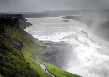 Mist rises over the canyon and tourists at Gullfoss in ...