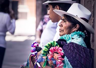Mexican woman with traditional dress selling dolls