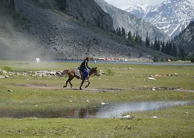Horse riding beside lake.