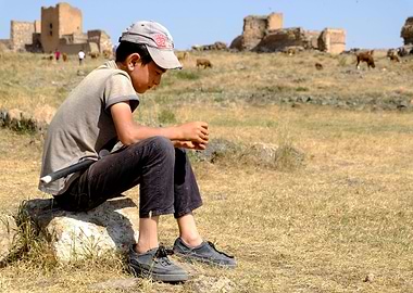 Kid sitting on a rock