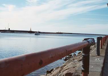 Red railing by the sea