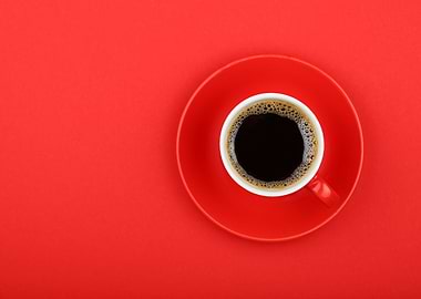 Cup of black coffee on red