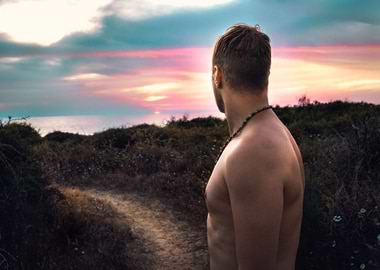 Man looking to sea sunset