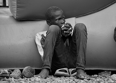 Young Boy Sitting by Inflatable Structure