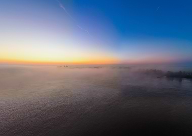 Misty sunset over water