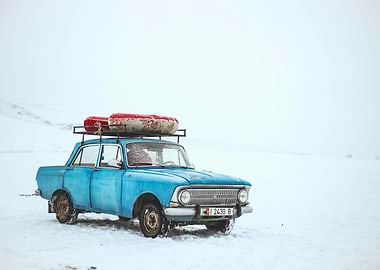 Blue Car in Snowy Landscape