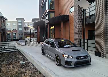 Modified nardo grey Subaru STI sits calmly in an urban enviroment