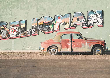 Route 66, USA I Vintage American car in front of a street art typography wall in Seligman, Arizona in the retro vintage american countryside during travel road trip on historic Route 66 in California