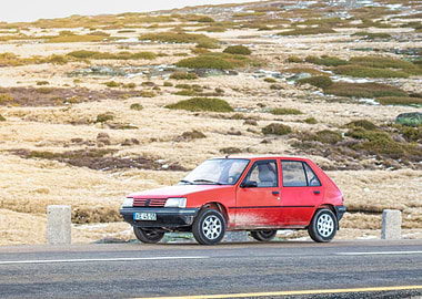 Red Peugeot 205 on Mountain Road