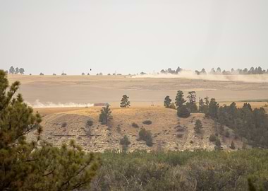 Dust Clouds From Semi-trucks Over the Hilltop In Montana
