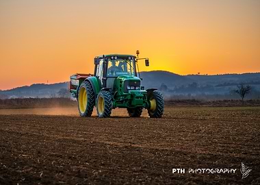 Green Tractor in Field at Sunset