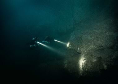 Scuba Divers Exploring Underwater Cave