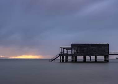 Wooden structure on water at dusk