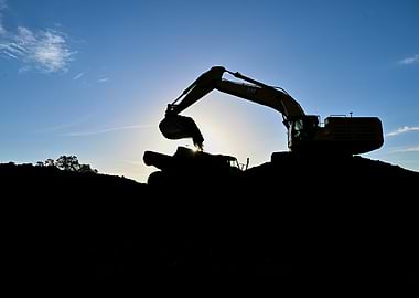 Excavator Silhouette Against Blue Sky