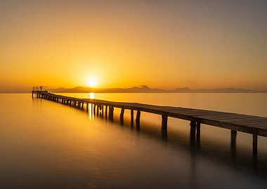 Golden Sunset Over Wooden Pier at Calm Sea