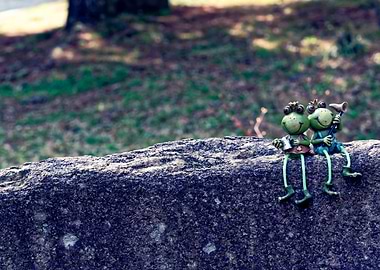 Two Frog Figurines on a Rock