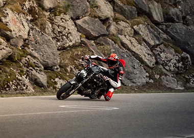 Motorcycle rider cornering on mountain road