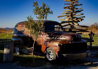 Rusty Truck with Wooden Sculpture
