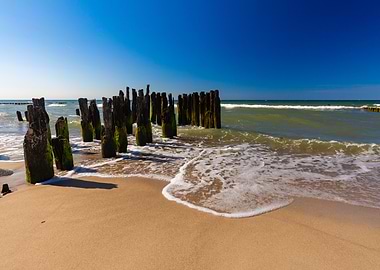 Beach with wooden breakwaters on sunny day, Poland