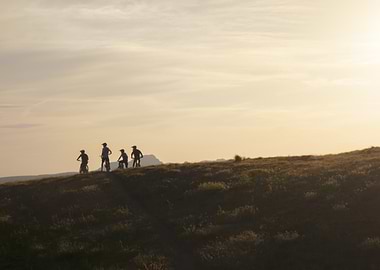 Cyclists on a hill at sunset