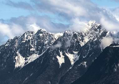 Snowy Alps Mountain Peaks Under Cloudy Sky