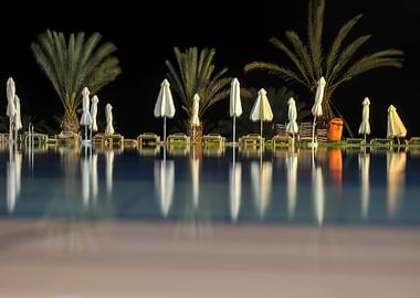 Night Pool with Umbrellas and Palms