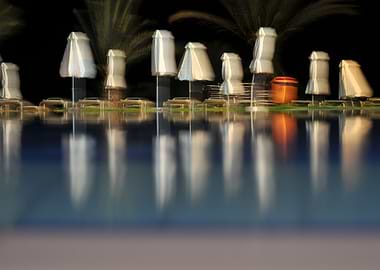 Night Poolside with Umbrellas and Reflections