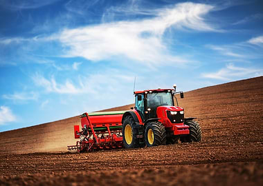 Red Tractor Plowing Field Under Blue Sky