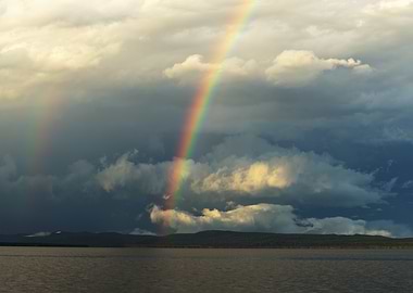 Rainbow over Lake and Cloudy Sky