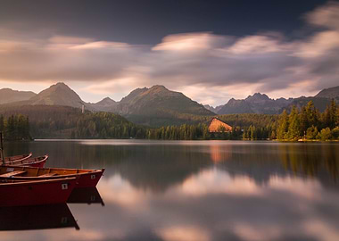 mountain lake with boats and reflections