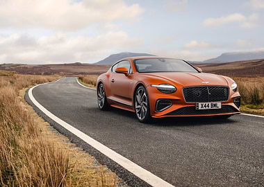 orange bentley on a winding road