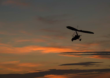 Microlight flying at sunset
