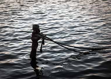Mooring post in water with ropes