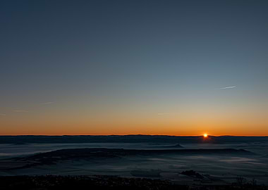 Sunrise over a misty landscape