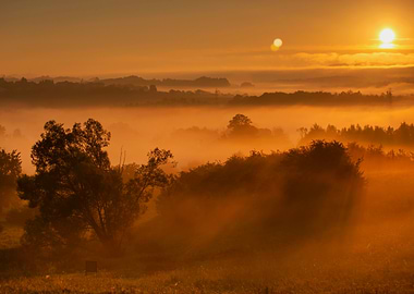 Golden Sunrise Over Misty Landscape