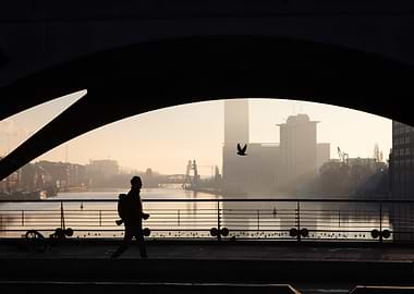 Silhouette of a person walking on bridge