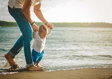 Father and child walking on beach