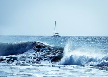 Ocean Waves and Distant Sailboat