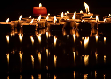 Candles with reflections on dark surface