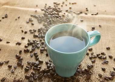 Steaming Coffee Cup with Coffee Beans