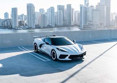 White Corvette with Cityscape Backdrop