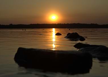 Golden Sunset Over Water with Rocks