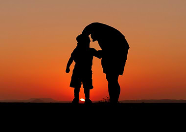 Silhouette of parent and child at sunset