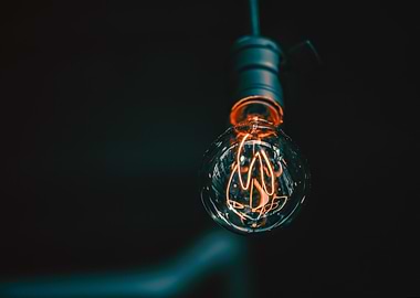 Glowing Filament Bulb on Dark Background