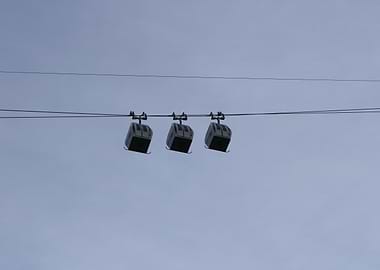 Three Cable Cars Against a Pale Sky