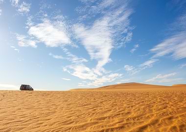Desert landscape with vehicle and sky