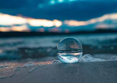 Crystal ball on beach at sunset