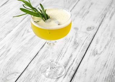 Yellow Cocktail with Rosemary Garnish