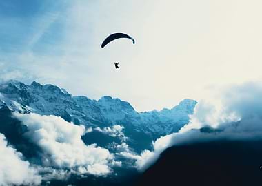 Paragliding over snowy mountains and clouds